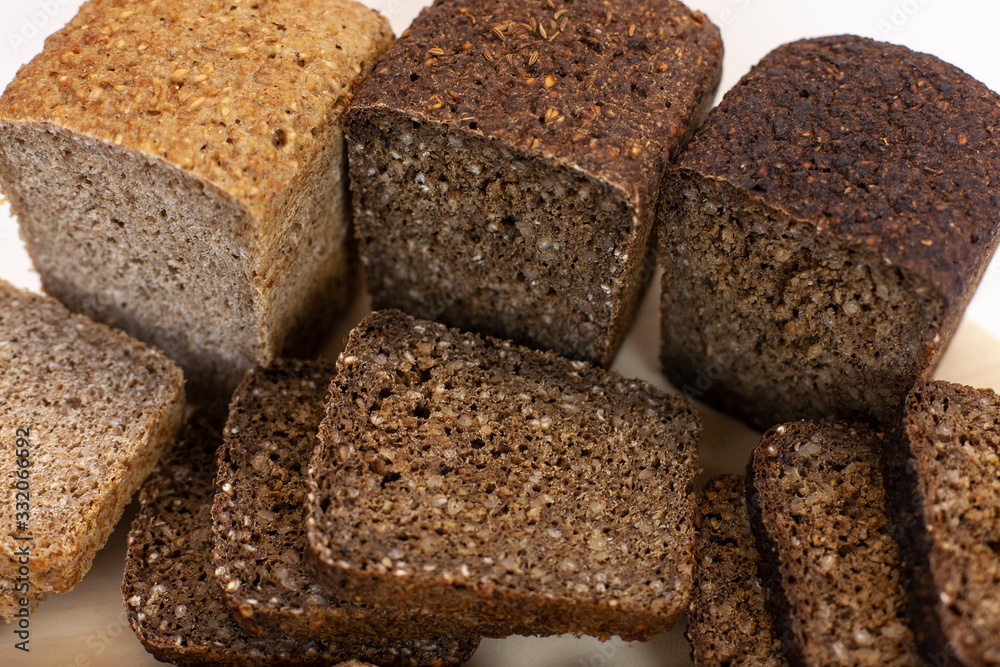Different varieties of bread on the kitchen table on a light background Different varieties of bread on the kitchen table on a light background