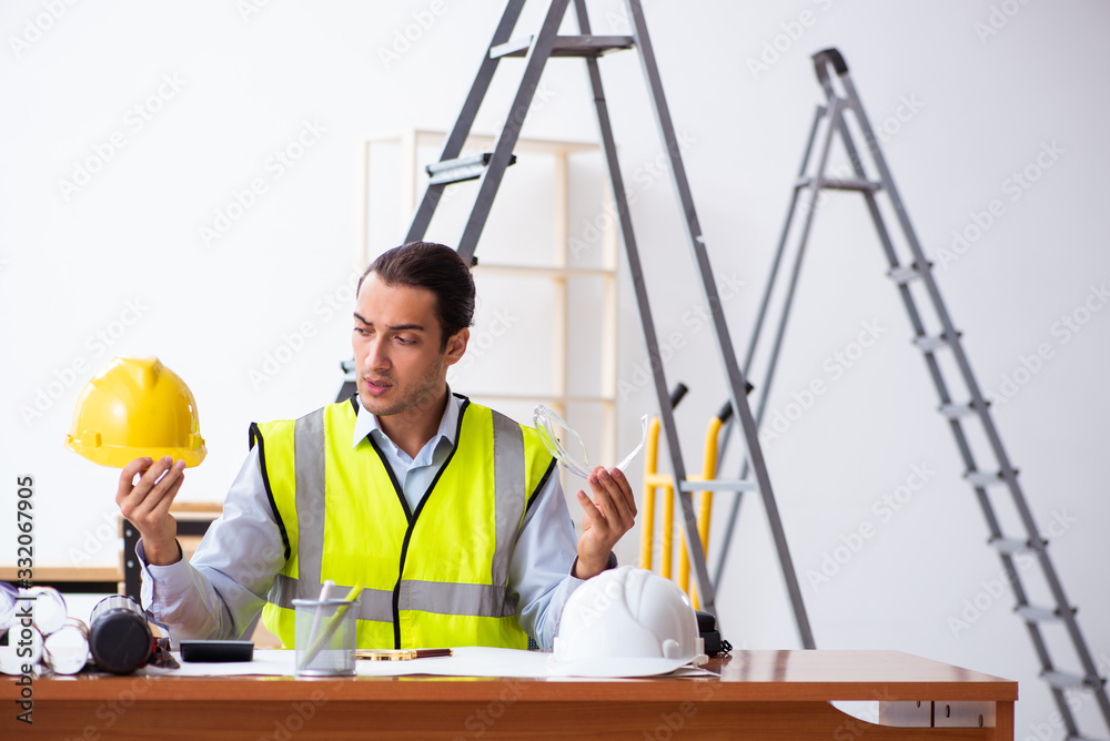 Young male architect working indoors Young male architect working indoors