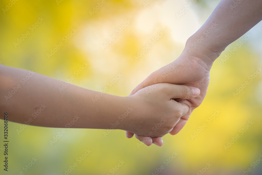Close up of Mother and son holding hand in hand . Isolated on nature background. Close up of Mother and son holding hand in hand . Isolated on nature background.