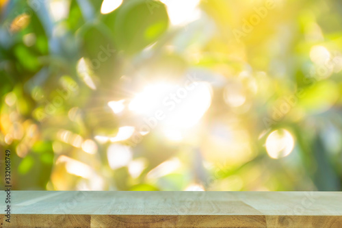 Display the product on a wooden table. The bokeh background from the sun is passing through the leaves