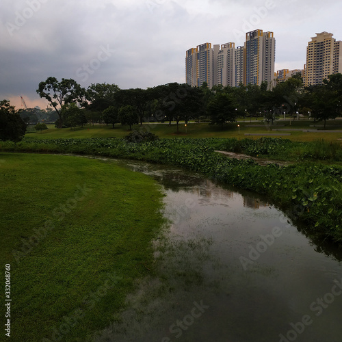 reflection of the residential buildings behind a neighborhood park pond
