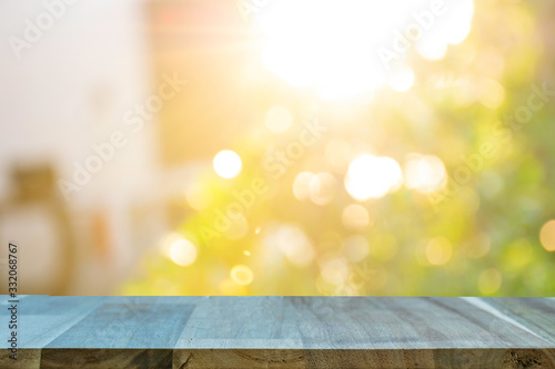 Display the product on a wooden table. The bokeh background from the sun is passing through the leaves