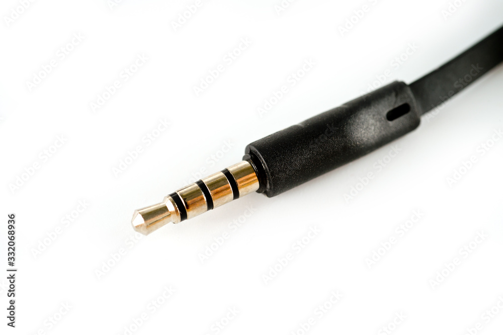 3.5 mm plug with a black wire, shot large on a white background. Background for music and computer equipment 3.5 mm plug with a black wire, shot large on a white background. Background for music and computer equipment
