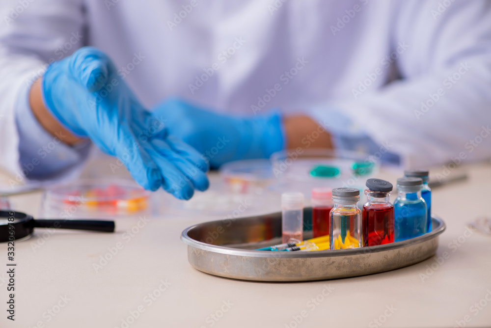 Young male lab assistant in drug synthesis concept Young male lab assistant in drug synthesis concept