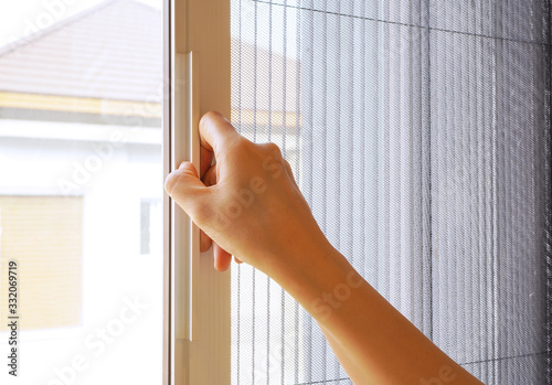 Εκτύπωση καμβά Woman hand hold retractable pleated insect screen holder to open or close the wi