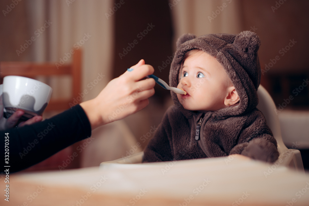 Φωτογραφία Baby Eating in Healthy Food Sitting in a Chair at the Restaurant