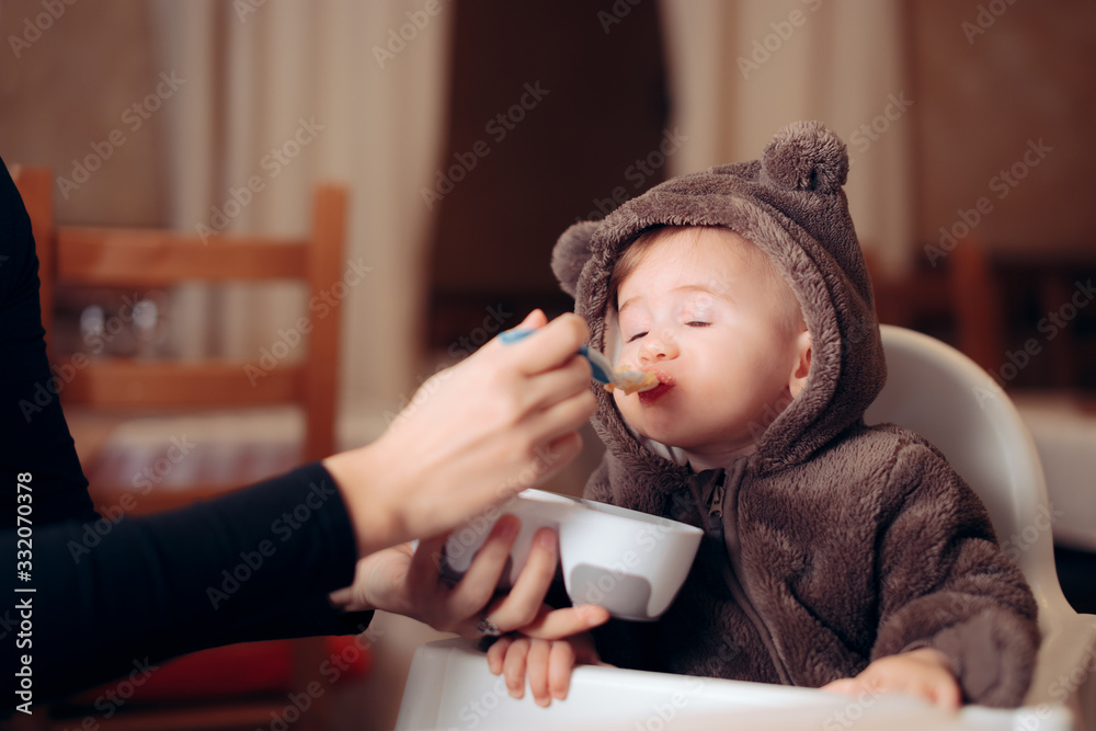 Φωτογραφία Baby Eating in Healthy Food Sitting in a Chair at the Restaurant