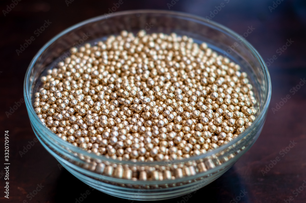 Close up of little golden balls in a clear transparent bowl. Close up of little golden balls in a clear transparent bowl.