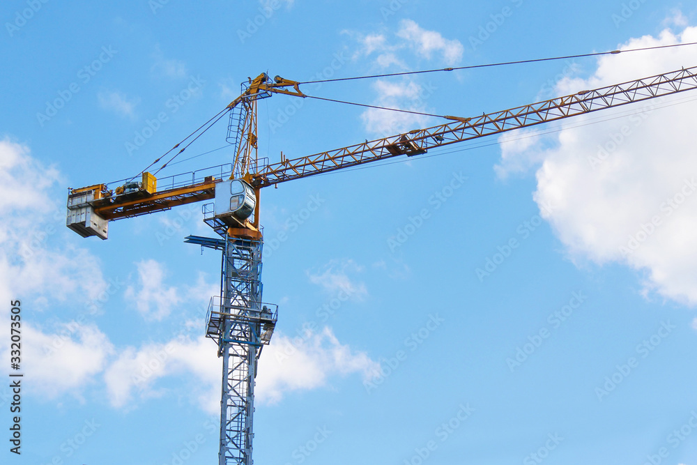 Crane. Construction crane. Building crane on the background of blue sky. Huge crane. Crane. Construction crane. Building crane on the background of blue sky. Huge crane.