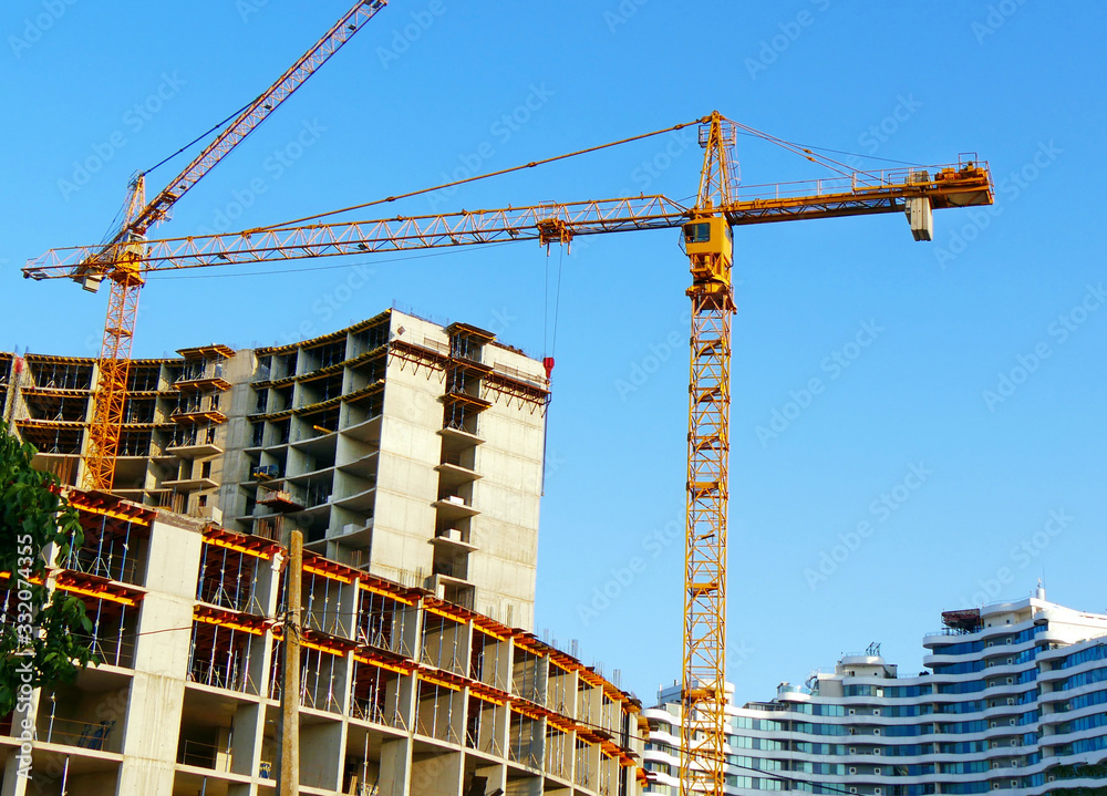 Two cranes near buildings. Construction site background.. Industrial background.