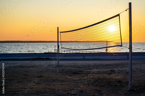 Sillhouette of a volleyball net against sunset on the beach © Elena Sistaliuk