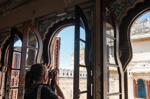 Photography Woman tourist photographer takes photos while visiting the City Palace in Udaipu