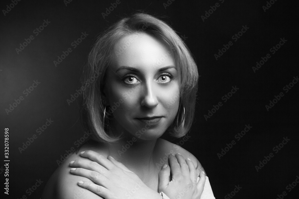 Classic black-and-white dramatic portrait of an blonde woman in Studio on black background.