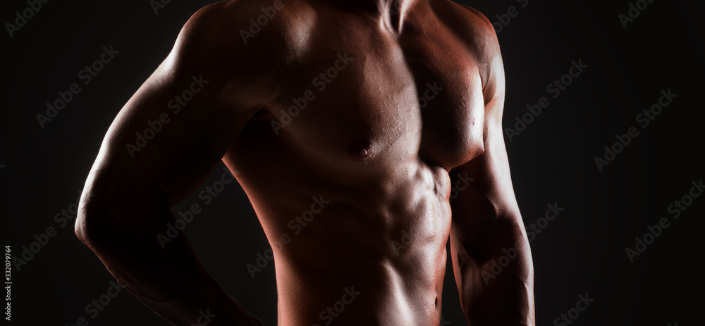 Strong, fit and sporty bodybuilder man over black background.