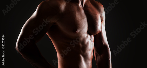 Strong, fit and sporty bodybuilder man over black background.