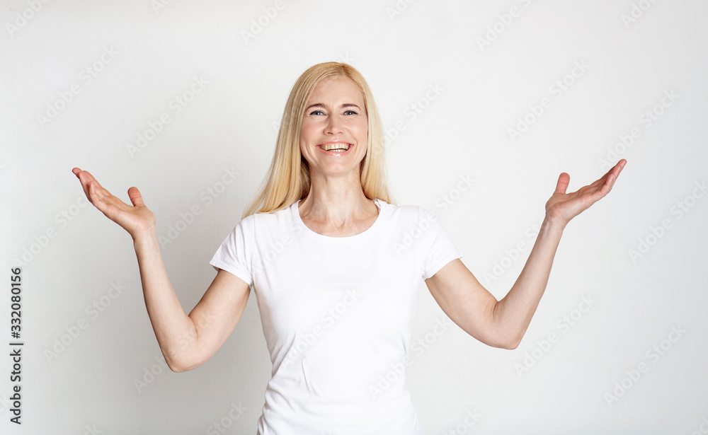 Happy middle-aged woman laughing at gray studio Happy middle-aged woman laughing at gray studio