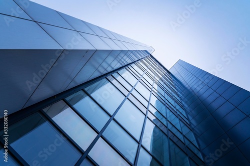 perspective, the skyscraper is directed to the sky. blue gradient, light reflection in glass, urban building design