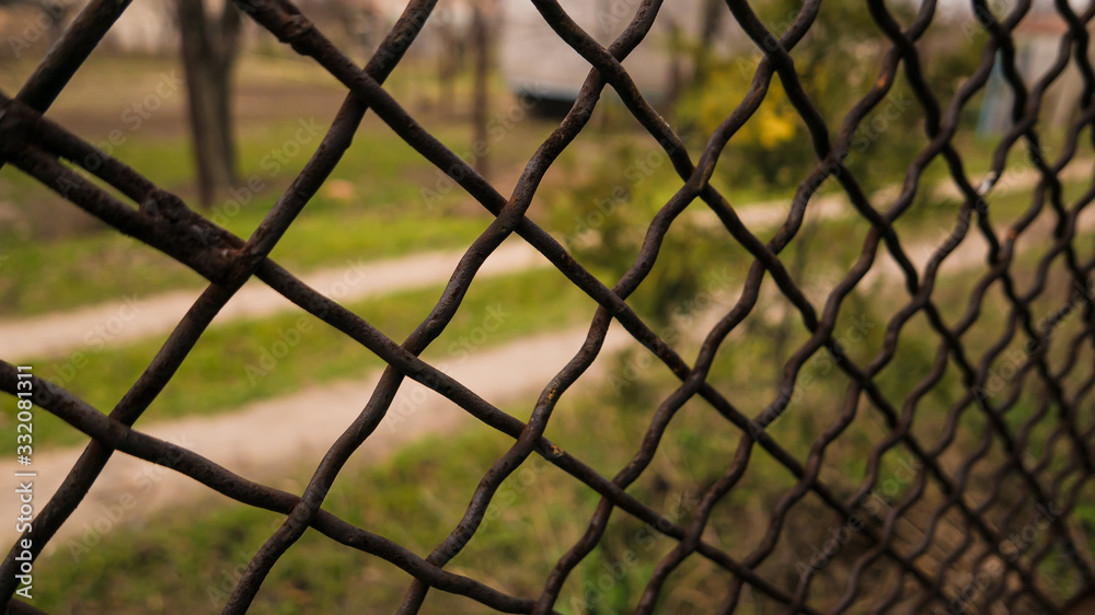 view of the landscape through an iron mesh view of the landscape through an iron mesh
