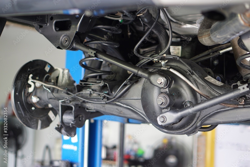 Obraz premium Suspension of drive car with new tire and Shock Absorber.Rear suspension of a modern car. Elements and design of the rear suspension. Rear suspension beam, spring, shock absorber.Close up.