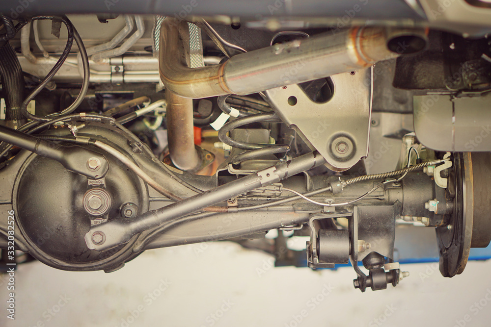 Obraz premium Suspension of drive car with new tire and Shock Absorber.Rear suspension of a modern car. Elements and design of the rear suspension. Rear suspension beam, spring, shock absorber.Close up.