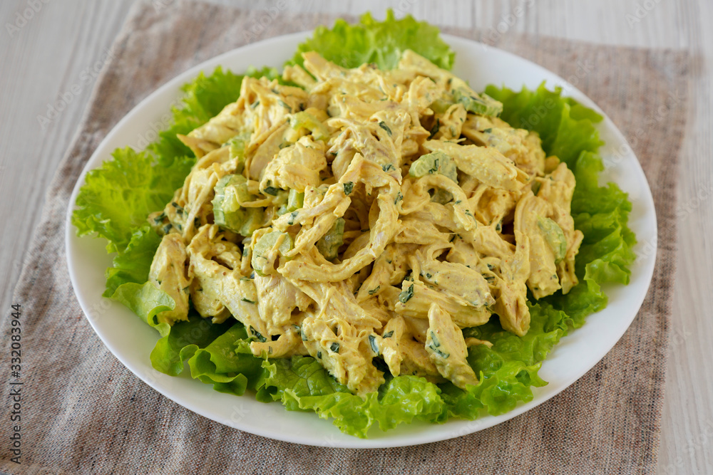 Homemade Curried Coronation Chicken Salad on a white plate, low angle view. Close-up.