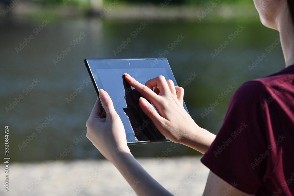 Female hands with a black graphic tablet