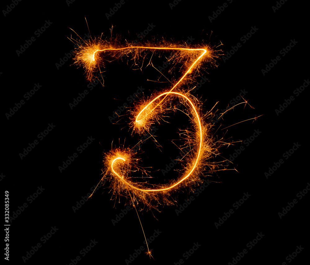 number three written with a sparkler on a black background