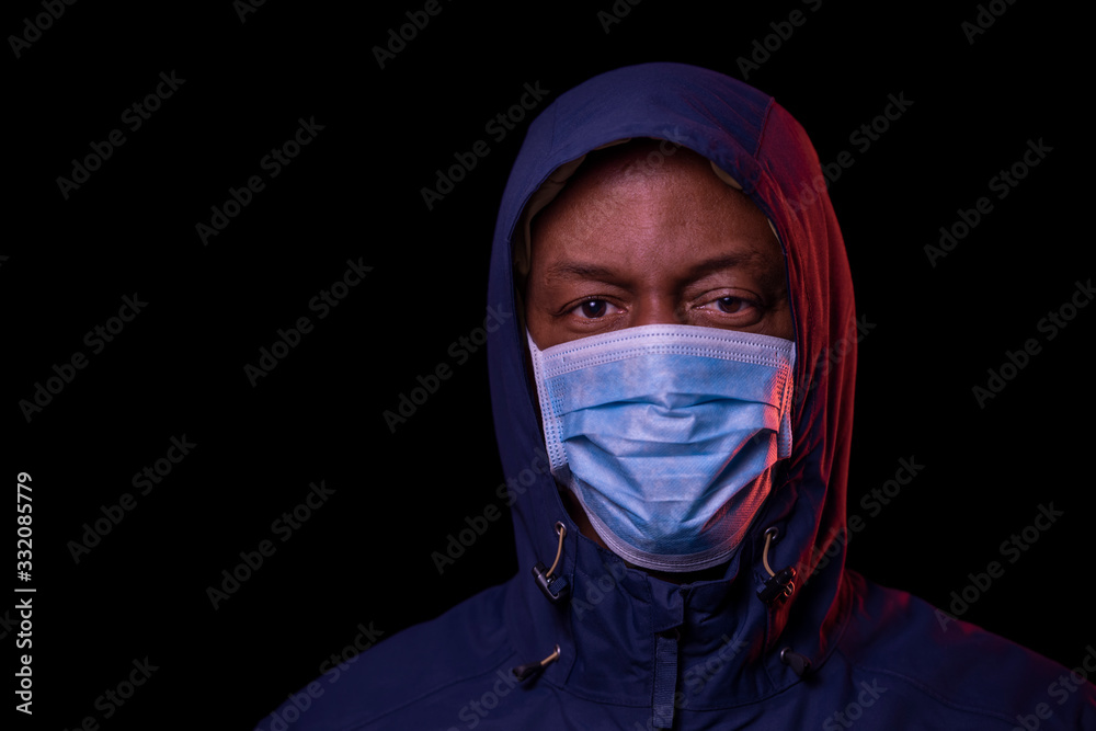 Coronavirus, African American man with protective mask, looking at the camera. COVID-19 concept. Studio shot on black background with copyspace. Coronavirus, African American man with protective mask, looking at the camera. COVID-19 concept. Studio shot on black background with copyspace.
