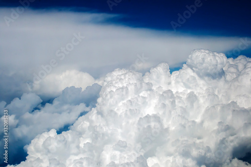 Aerial view on incredibly wonderful lush cumulus clouds against a blue sky.