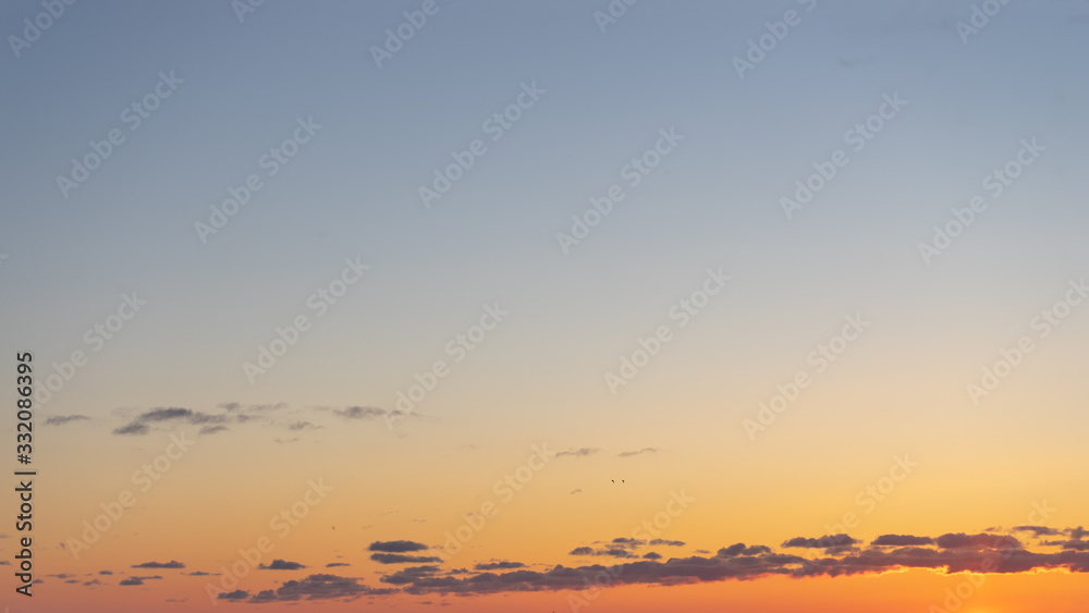 Beautiful clear, morning sky at sunrise, natural background. Soft gradient from orange to blue.