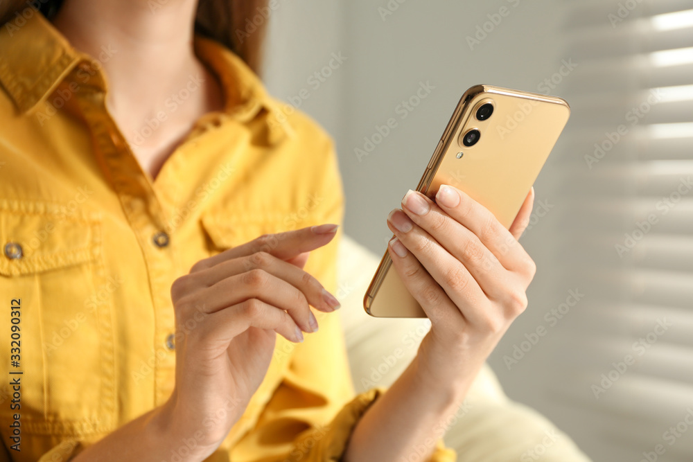 Young woman using modern smartphone indoors, closeup Young woman using modern smartphone indoors, closeup