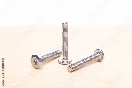 Hex head bolt screws on wooden table. Close up view photo