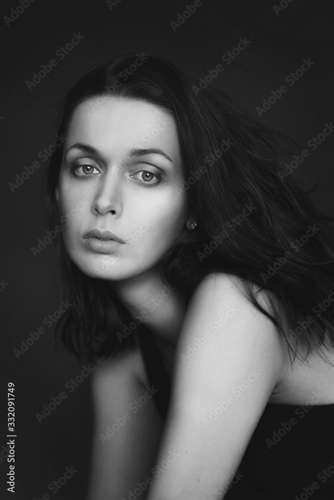 Portrait of a woman in black and white, she looks directly into the camera with her eyes wide open
