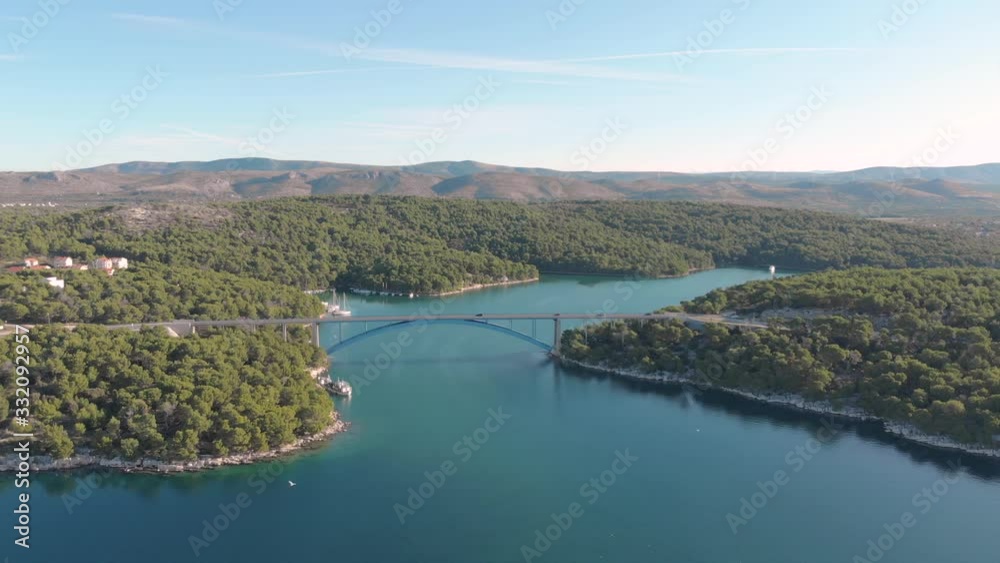 Aerial view of highway bridge in a natural wild environment mountain and sea, traffic car and yacht parking on the river. Aerial view of highway bridge in a natural wild environment mountain and sea, traffic car and yacht parking on the river.