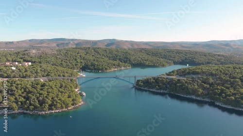 Aerial view of highway bridge in a natural wild environment mountain and sea, traffic car and yacht parking on the river. photo
