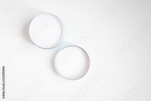 Closed jar of cream and lid on a white background top view
