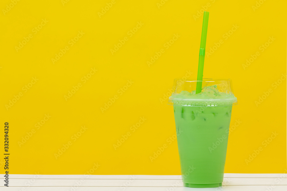 green beverage and green straw on yellow background green beverage and green straw on yellow background