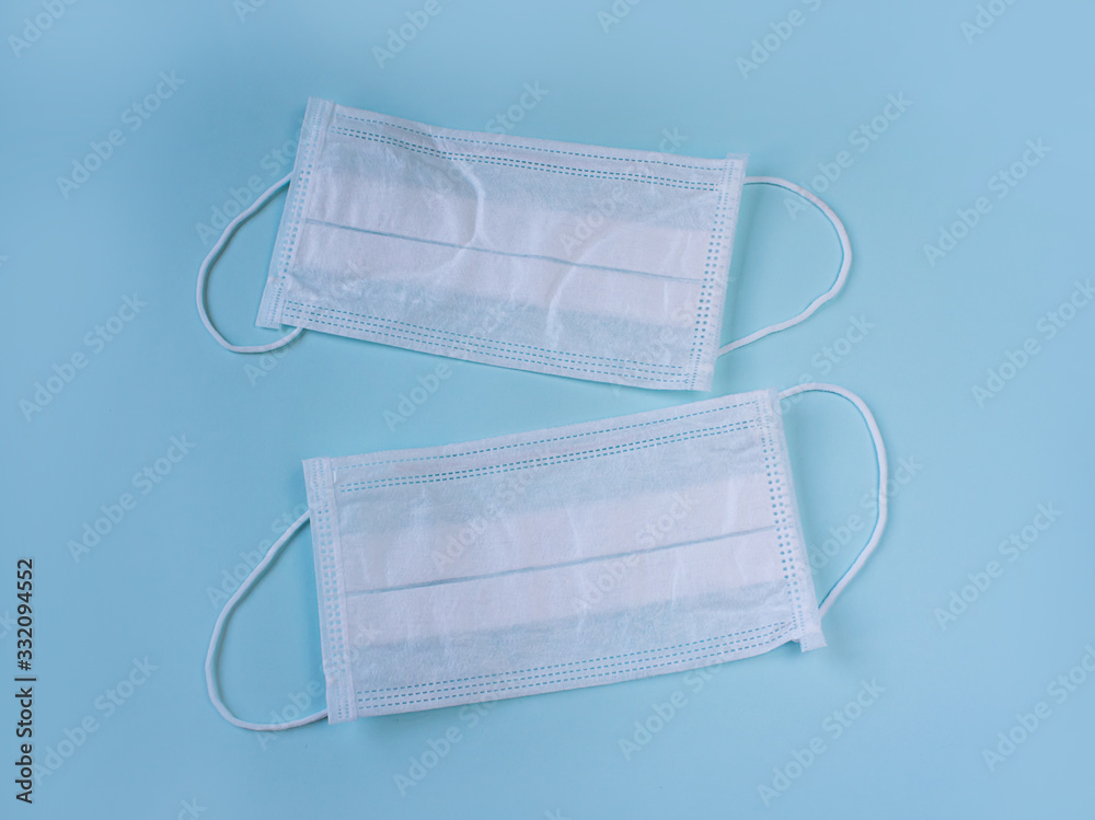 white medical masks on a blue background, a means of protection against the virus, doctor's accessory white medical masks on a blue background, a means of protection against the virus, doctor's accessory