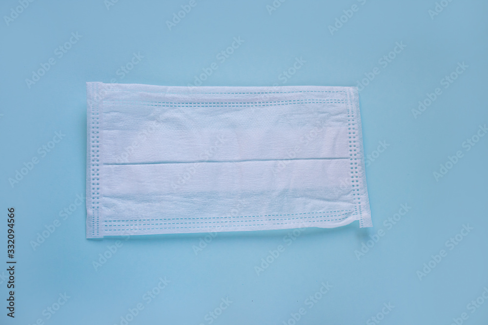 protective white medical mask on a blue background, a means of protection against the virus protective white medical mask on a blue background, a means of protection against the virus
