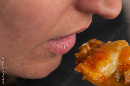 Woman eat with  metal spoon.Close up