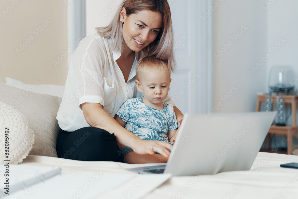 Modern woman working with child. Multi-tasking, freelance and motherhood concept Modern woman working with child. Multi-tasking, freelance and motherhood concept