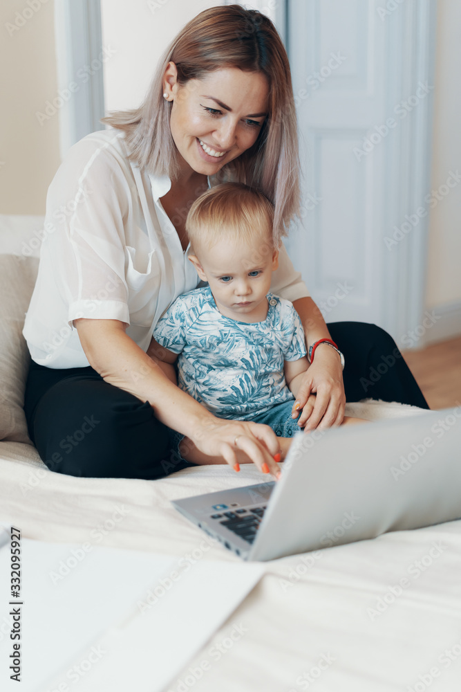 Modern woman working with child. Multi-tasking, freelance and motherhood concept Modern woman working with child. Multi-tasking, freelance and motherhood concept