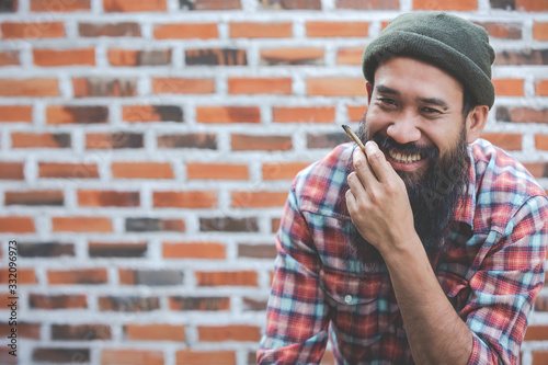 mustache man smoke marijuanna joint on brick wall background