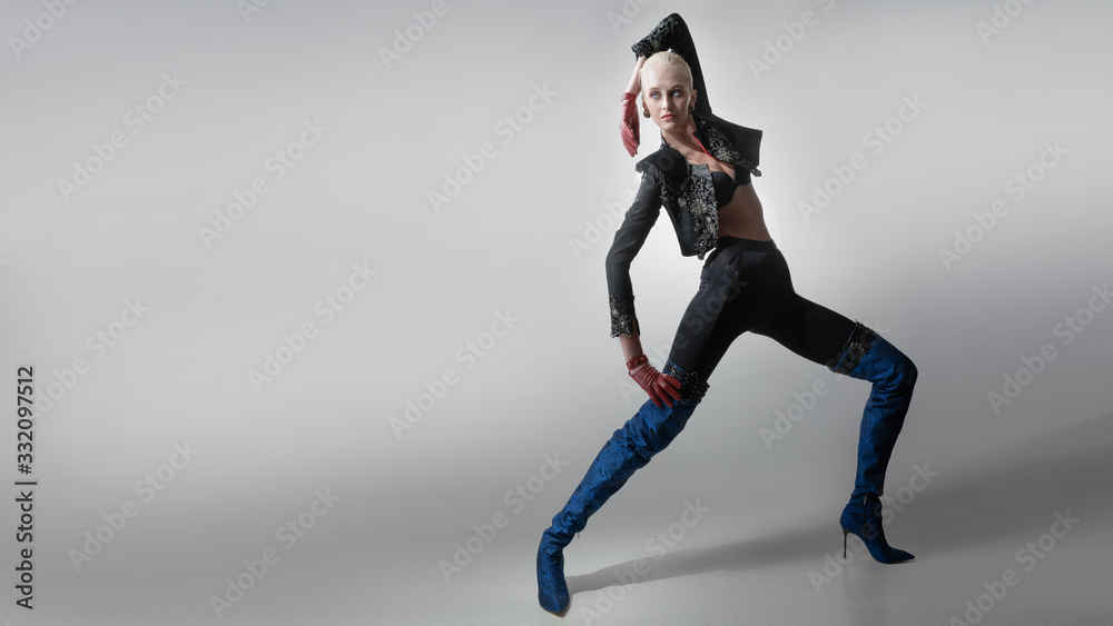A girl poses on a gray background in beautiful fashionable clothes A girl poses on a gray background in beautiful fashionable clothes
