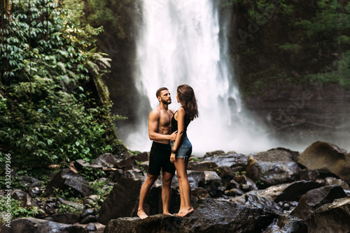 A couple in love on a waterfall. Honeymoon trip. Happy couple on the island of Bali. Beautiful couple travels the world. Travel to Indonesia. Happy couple on vacation. Wedding trip