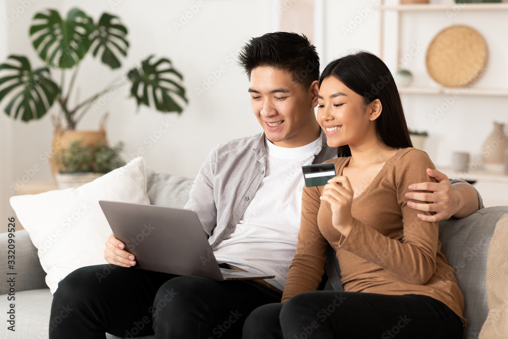 Filipino couple using laptop and credit card Filipino couple using laptop and credit card