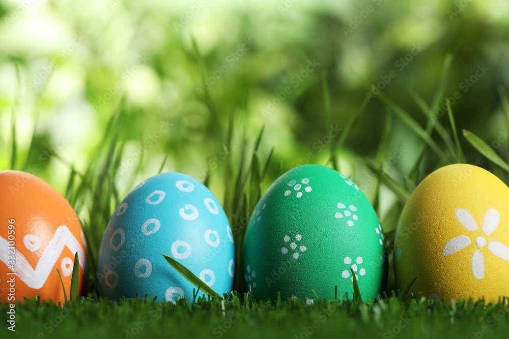 Colorful Easter eggs in green grass, closeup