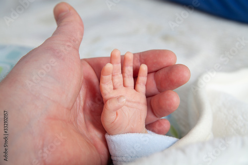 holding a hand of newborn child