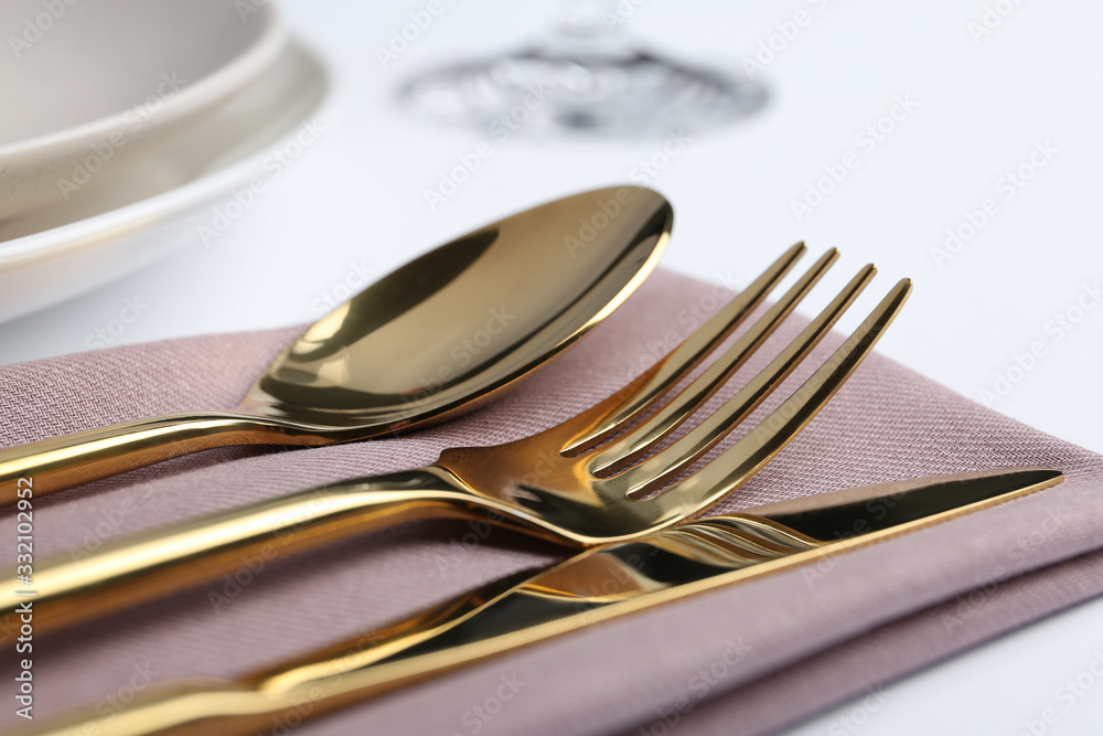 Stylish elegant cutlery set with napkin on white table, closeup Stylish elegant cutlery set with napkin on white table, closeup