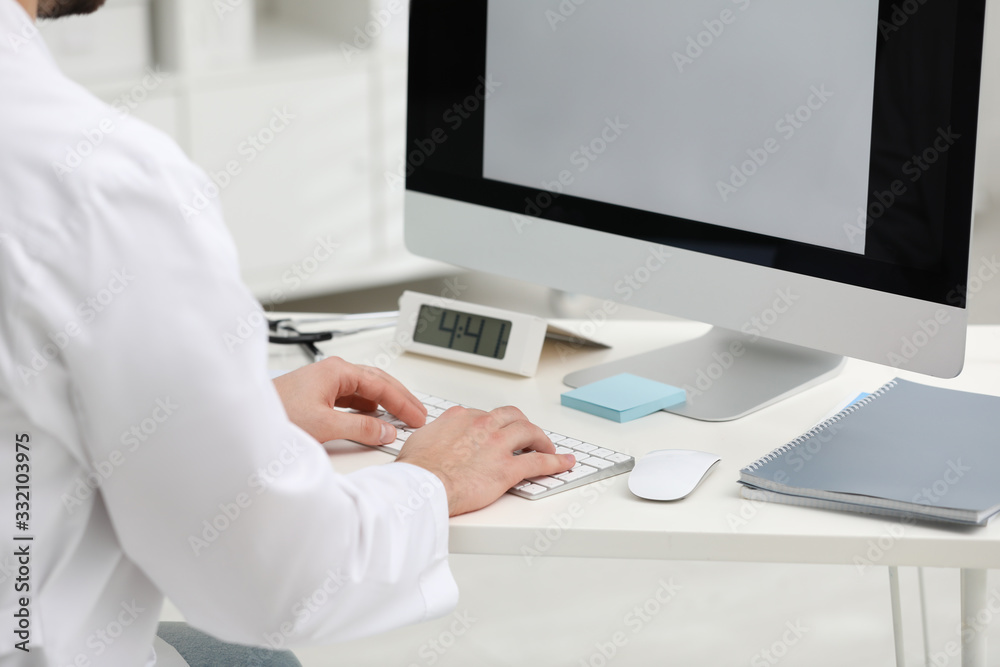 Doctor working with computer at desk in office, closeup Doctor working with computer at desk in office, closeup